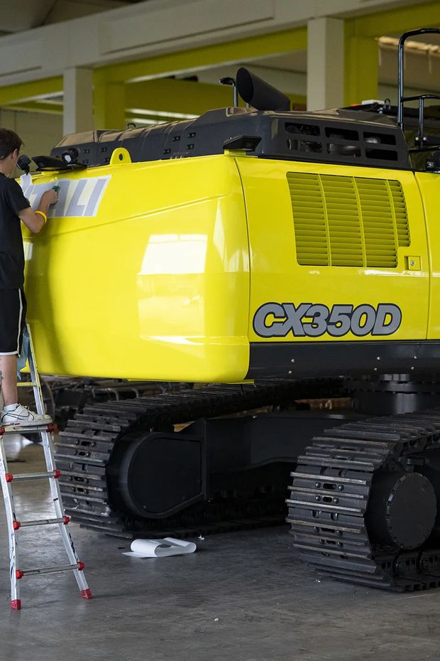 Applicatore WrapLab al lavoro su un escavatore giallo